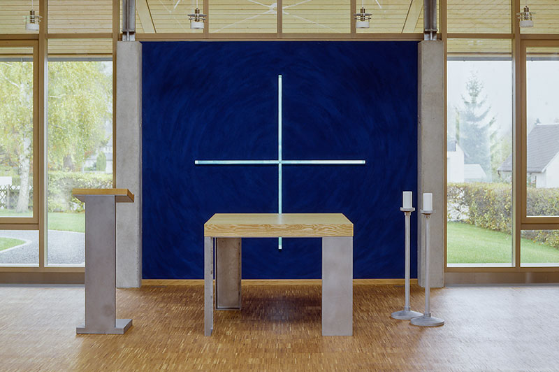 Altarraum, im Hintergrund Plexiglaskreuz in dunkelblauer Wand