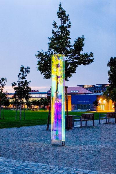 Beleuchtete Glasstele nachts