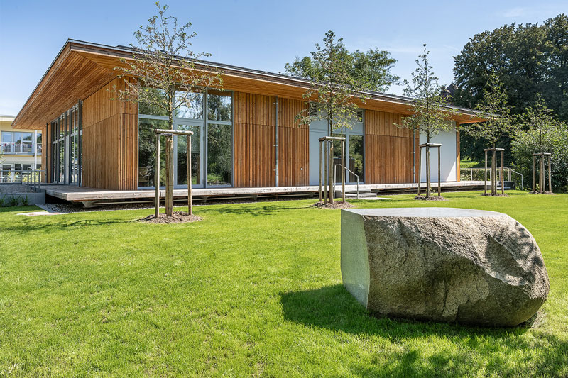 Aussenansicht des Gemeindezentrums mit Altar im Vordergrund